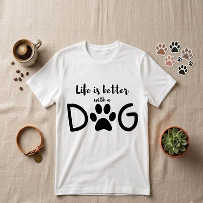 White t-shirt with 'Life is better with a dog' text on a beige surface with decorative items.